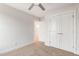 Bright bedroom featuring neutral carpet, ceiling fan, large window, double door closet and an open door at 306 E Godwin St, Dunn, NC 28334
