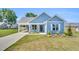 Charming blue home featuring a covered entrance, well-manicured lawn, and inviting curb appeal at 306 E Godwin St, Dunn, NC 28334