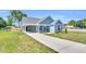 Lovely blue home showcasing a covered entrance, light landscaping, and a long driveway at 306 E Godwin St, Dunn, NC 28334