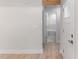 Hallway featuring wood-look floors, a view into the bathroom, and a glimpse of natural light at 306 E Godwin St, Dunn, NC 28334