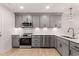 Well-lit kitchen featuring stainless steel appliances, grey cabinetry, and quartz countertops at 306 E Godwin St, Dunn, NC 28334