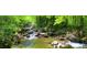 Picturesque creek with clear water cascading over rocks surrounded by vibrant green foliage and mature trees at 67 Ridgeline Ct # 7, Pittsboro, NC 27312