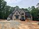 New construction home with brick facade, dark roof, and a large lot in a wooded setting at 67 Ridgeline Ct # 7, Pittsboro, NC 27312