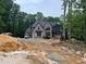 New brick home construction surrounded by a green forest with a black roof and modern design at 67 Ridgeline Ct # 7, Pittsboro, NC 27312