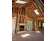 Framing stage of a living room featuring a fireplace, skylights, and French doors at 67 Ridgeline Ct # 7, Pittsboro, NC 27312