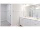 Bathroom with dual sinks, white cabinets, large mirror, and walk-in closet access at 7417 Prato Ct, Wendell, NC 27591