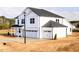 Corner view of new construction home with a three-car garage, white siding, dark roof, and covered porch at 7417 Prato Ct, Wendell, NC 27591