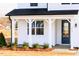 Close up of the covered front porch and blue front door of this new construction home at 7417 Prato Ct, Wendell, NC 27591