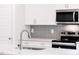 Bright kitchen features white cabinets, stainless appliances, and stylish backsplash at 7417 Prato Ct, Wendell, NC 27591