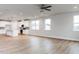 Bright, open living area featuring wood floors, large windows, and a kitchen with white cabinets at 7417 Prato Ct, Wendell, NC 27591