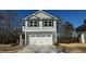 Two-story home with gray siding, stone accents, and a two-car garage at 211 Hopewell Branch Ct, Smithfield, NC 27577