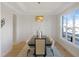 Elegant dining room with modern lighting, large window, and sleek hardwood flooring at 2525 Silas Peak Ln, Apex, NC 27523