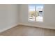 Bright empty room with hardwood flooring and large window overlooking the neighborhood at 2525 Silas Peak Ln, Apex, NC 27523