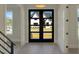 Bright foyer featuring a modern front door with glass panels and light hardwood flooring at 2525 Silas Peak Ln, Apex, NC 27523