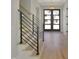 Bright foyer featuring modern stairs with metal railings, hardwood floors, and a stylish chandelier at 2525 Silas Peak Ln, Apex, NC 27523