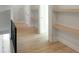 Upstairs hallway features sleek, light wood floors, white walls and leads to a walk-in closet at 2525 Silas Peak Ln, Apex, NC 27523