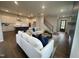 Open concept living room and kitchen featuring hardwood floors, plush sofas, and modern appliances at 321 Murray Grey Ln, Wake Forest, NC 27587