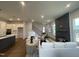 Living room and kitchen with dark hardwood floors, a fireplace, and modern decor throughout at 321 Murray Grey Ln, Wake Forest, NC 27587