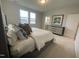 Cozy main bedroom featuring large windows, neutral carpet, and an ensuite bathroom at 321 Murray Grey Ln, Wake Forest, NC 27587