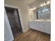 Bright bathroom featuring double sinks, modern lighting, and walk-in closet access at 104 Gin Branch Rd, Wendell, NC 27591