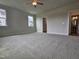Spacious bedroom featuring carpet, fan, and ensuite bathroom access, illuminated by natural light at 104 Gin Branch Rd, Wendell, NC 27591