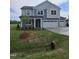 A two-story home with a two-car garage, front lawn with immature tree, and concrete driveway at 104 Gin Branch Rd, Wendell, NC 27591