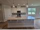 Kitchen featuring a large island with quartz countertops, white cabinets, and stainless steel appliances at 104 Gin Branch Rd, Wendell, NC 27591