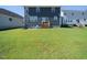 View of a spacious backyard with lush green grass leading up to a modern two-story home at 137 Shadowdale Ln, Rolesville, NC 27571