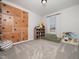 Playroom with climbing wall, plush carpet, window, and storage shelves at 137 Shadowdale Ln, Rolesville, NC 27571