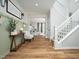 Inviting foyer with hardwood floors, staircase, sage green accent wall, and a view into the living room at 137 Shadowdale Ln, Rolesville, NC 27571