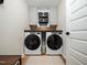 Modern laundry room with dual washer and dryer, cabinets, and a wood countertop at 137 Shadowdale Ln, Rolesville, NC 27571