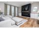 Cozy living room with a fireplace, TV, built-in cabinets, hardwood floors, and a comfortable couch at 137 Shadowdale Ln, Rolesville, NC 27571