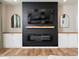 Living room with a fireplace, television, built-in cabinets, hardwood floors, and decorative mirrors at 137 Shadowdale Ln, Rolesville, NC 27571