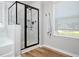 Modern bathroom shower with marble tile surround, dark fixtures, and a built-in shower bench at 137 Shadowdale Ln, Rolesville, NC 27571