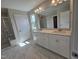 Elegant bathroom features a double sink vanity, marble floors, and glass shower at 7420 Prato Ct, Wendell, NC 27591