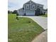 Charming two-story home with a three-car garage, stone details, and a freshly sodded lawn at 7420 Prato Ct, Wendell, NC 27591