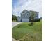 New two-story home featuring a three-car garage, stone accents, and a meticulously landscaped front yard at 7420 Prato Ct, Wendell, NC 27591