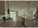 Open-concept kitchen with island seating, stainless steel appliances, quartz counters, and backyard views at 7420 Prato Ct, Wendell, NC 27591