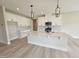 Modern kitchen with white cabinets, quartz countertops, stainless steel appliances, and pendant lighting at 7420 Prato Ct, Wendell, NC 27591