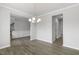 Bright dining room with elegant chandelier, wainscoting, and modern wood flooring at 1301 Jasmine View Way, Knightdale, NC 27545