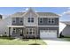 Charming two-story home with a gray facade, well-manicured lawn, and a two-car garage at 1301 Jasmine View Way, Knightdale, NC 27545