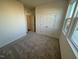 Neutral bedroom featuring carpet, double door closet, and large windows allowing ample natural light at 29 Longdale Dr, Graham, NC 27253