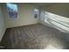 A spacious carpeted bedroom provides sunlight and calming views of nature through its two windows at 29 Longdale Dr, Graham, NC 27253