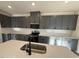 Stylish kitchen featuring gray cabinets, stainless steel appliances, and a center island at 29 Longdale Dr, Graham, NC 27253