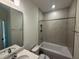 Well-lit bathroom with tile surround bathtub and shower, plus a single sink vanity at 135 Green Haven Blvd # 1, Youngsville, NC 27596