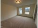 Bedroom with neutral carpet and two large windows offering views of the outside at 135 Green Haven Blvd # 1, Youngsville, NC 27596