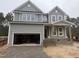 Two-story home showcasing a gray exterior, inviting front porch, and a convenient two-car garage at 135 Green Haven Blvd # 1, Youngsville, NC 27596