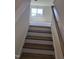 Staircase with wooden steps leading to a carpeted area and a bright window at 135 Green Haven Blvd # 1, Youngsville, NC 27596