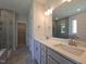 Beautiful primary bathroom with double vanity, quartz countertop, tile floors, and a glass-enclosed shower at 145 Green Haven Blvd # 83, Youngsville, NC 27596