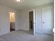 Cozy bedroom with carpet flooring featuring multiple doorways and natural light, creating a peaceful atmosphere at 145 Green Haven Blvd # 83, Youngsville, NC 27596